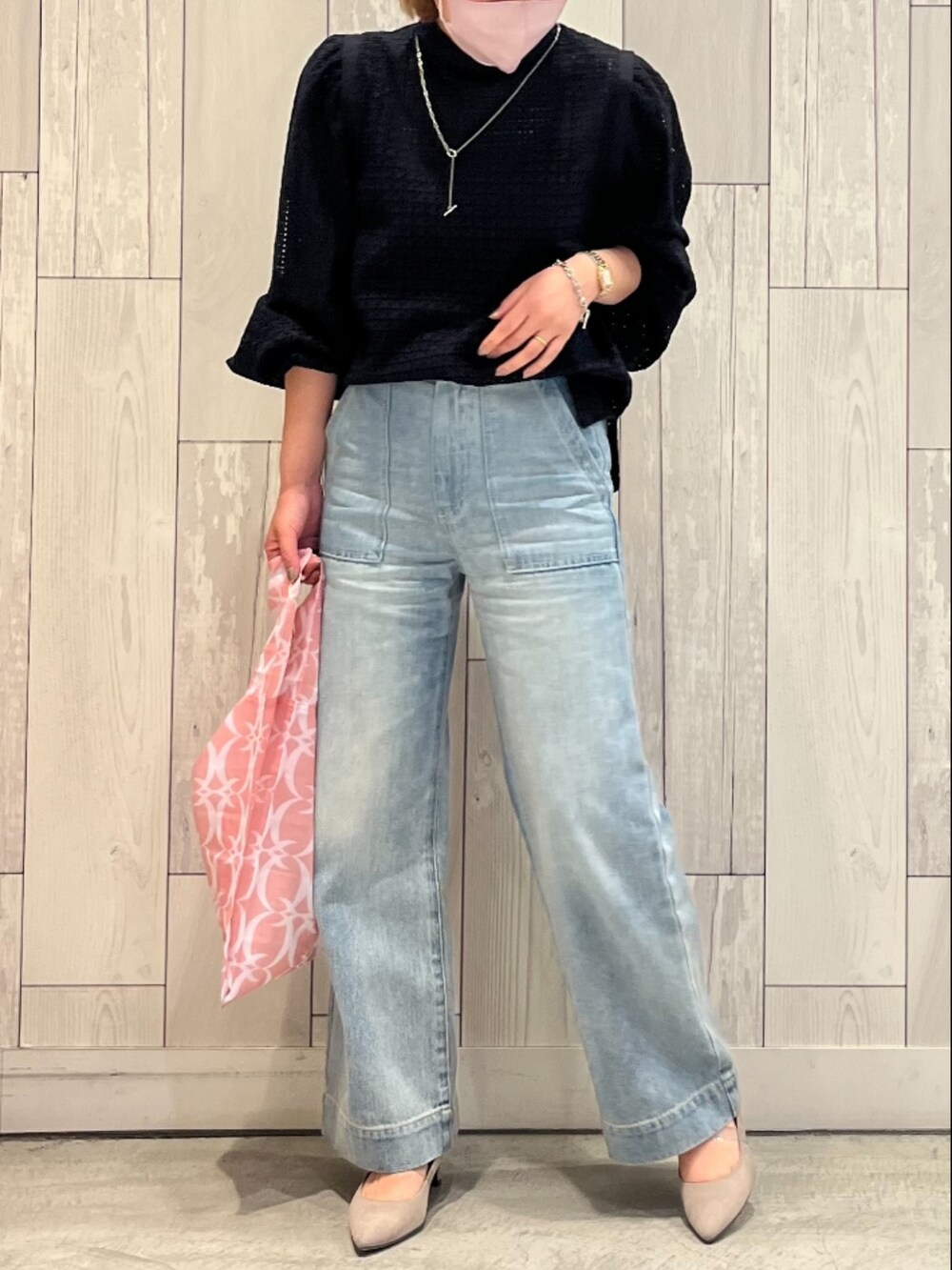 ブルー系のデニムパンツ、ピンク系のエコバッグ/サブバッグ、ブラック系のシャツ/ブラウスを着用したレディースの春コーディネートの2枚目の写真