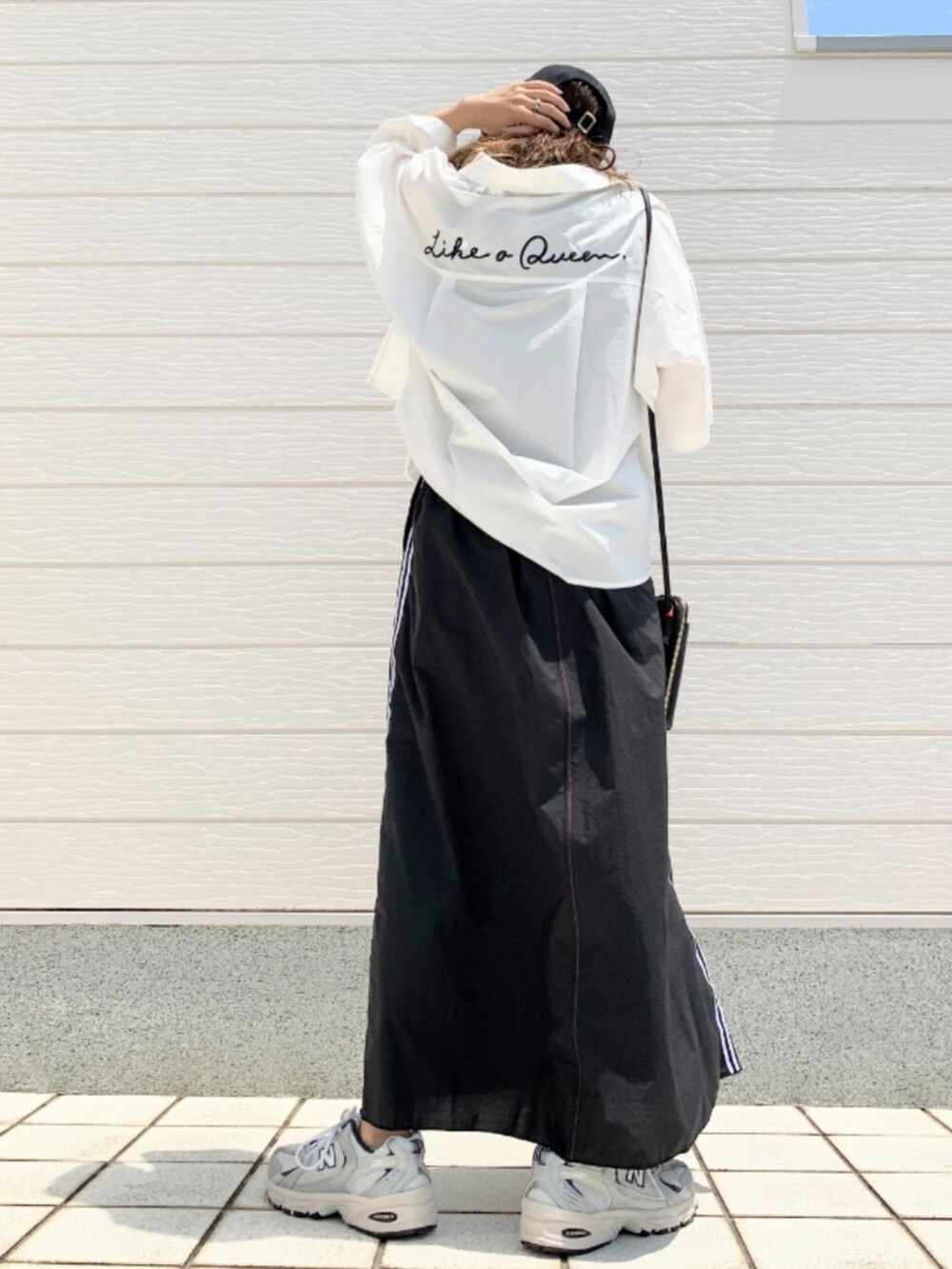 シルバー系のスニーカー、ホワイト系のシャツ/ブラウス、ブラック系のショルダーバッグを着用したレディースの夏コーディネートの3枚目の写真