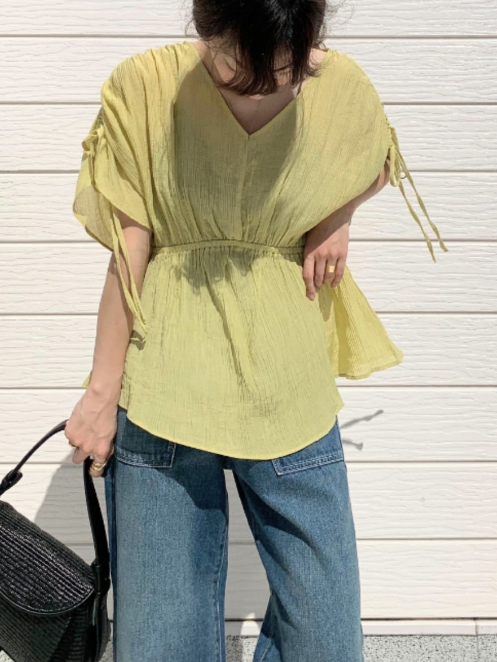 ブラック系のショルダーバッグ、ブラウン系のサンダル、イエロー系のシャツ/ブラウスを着用したレディースの春コーディネートの4枚目の写真