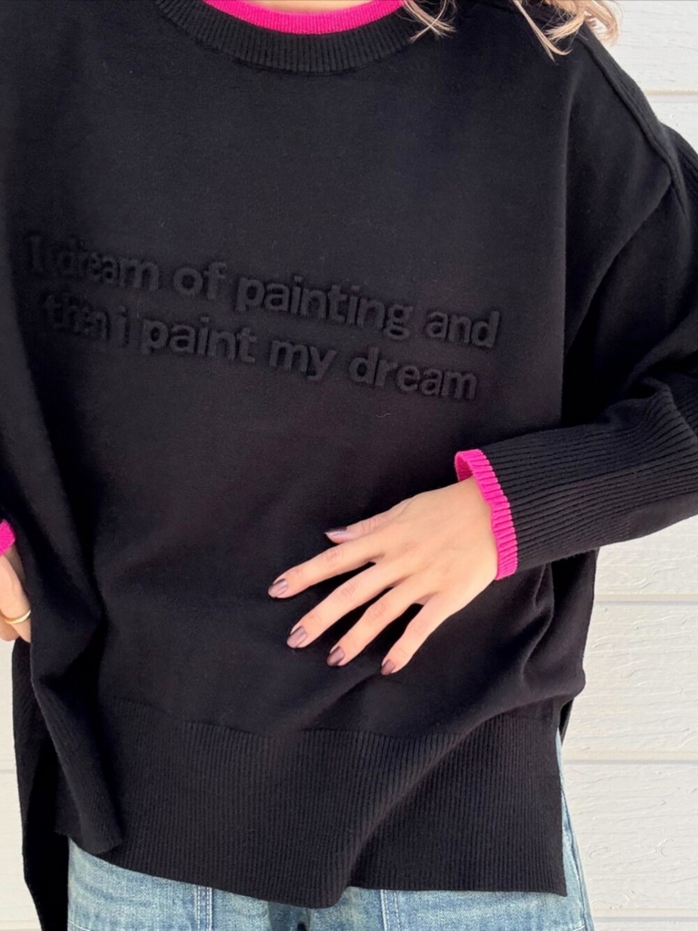 レッド系のトートバッグ、ブルー系のデニムパンツ、ブラック系のニット/セーターを着用したレディースの秋コーディネートの5枚目の写真