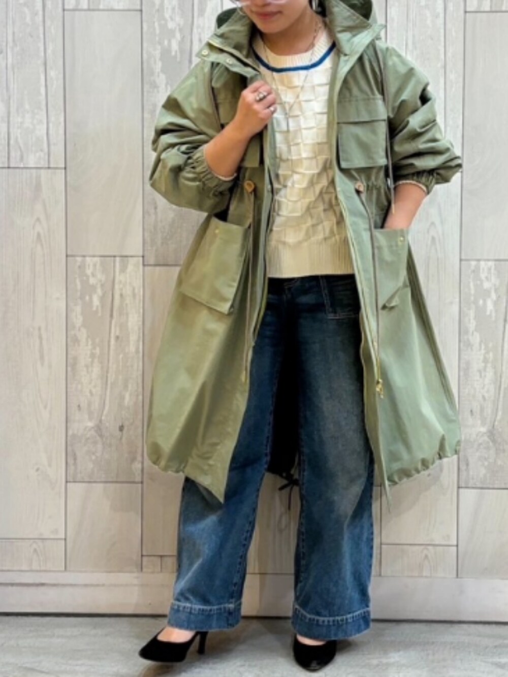 ブルー系のデニムパンツ、ホワイト系のニット/セーター、グリーン系のモッズコートを着用したレディースの冬コーディネートの2枚目の写真