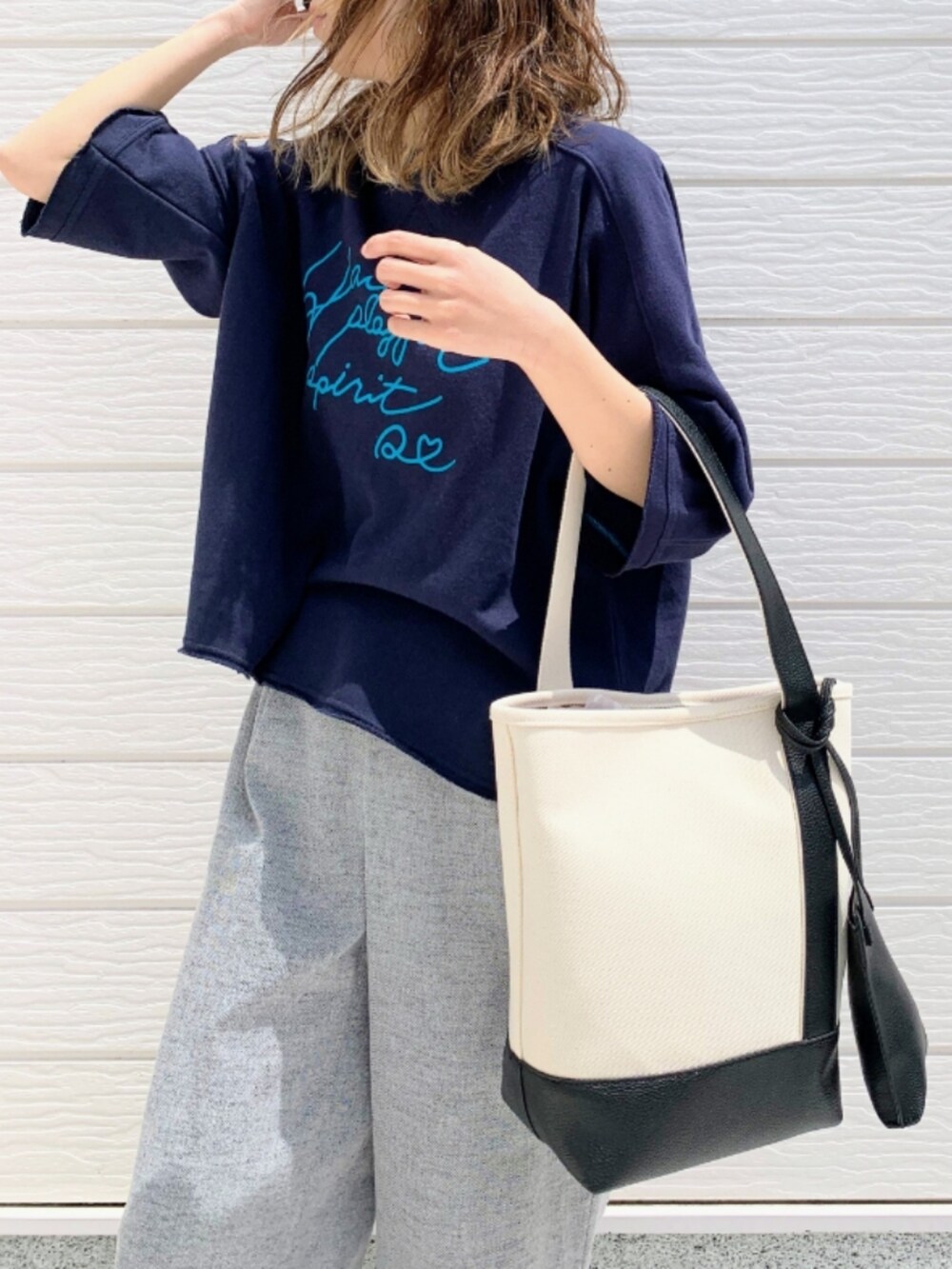 ブルー系のスウェット、グレー系のその他パンツ、ブラック系のハンドバッグを着用したレディースの春コーディネートの4枚目の写真