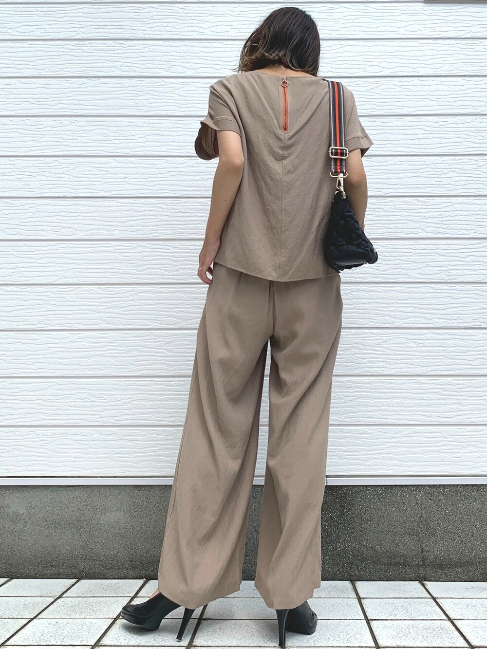 ブラック系のショルダーバッグ、ベージュ系のその他パンツ、ベージュ系のシャツ/ブラウスを着用したレディースの夏コーディネートの2枚目の写真