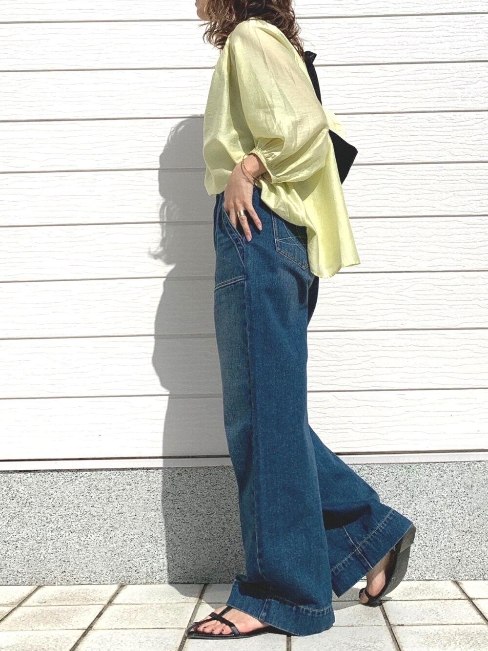 ブルー系のデニムパンツ、ブラック系のショルダーバッグ、グリーン系のシャツ/ブラウスを着用したレディースの春コーディネートの3枚目の写真