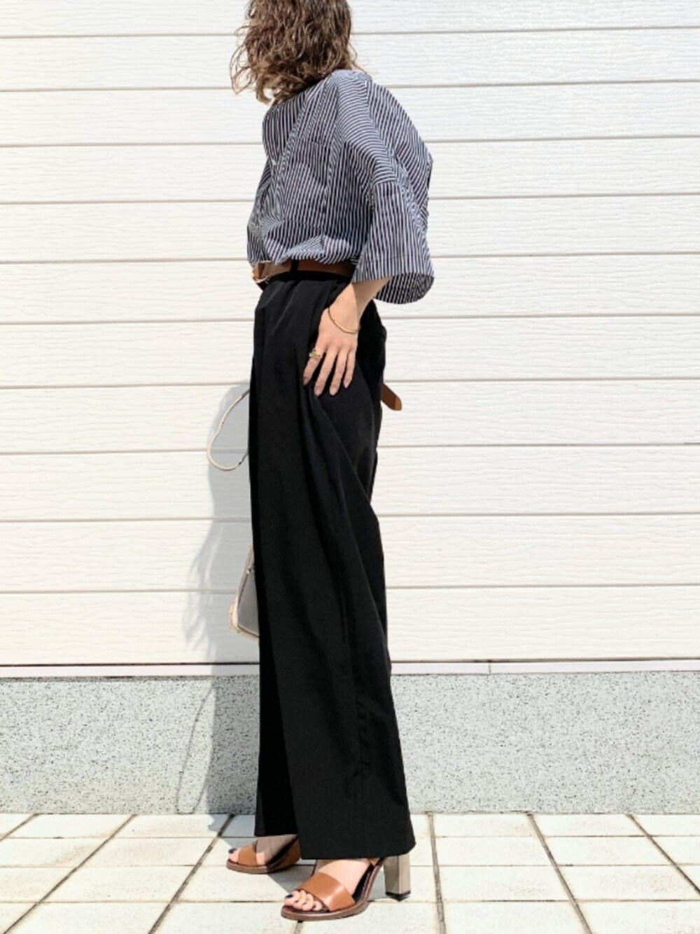 ブラック系のその他パンツ、ブラック系のシャツ/ブラウス、ブラウン系のサンダルを着用したレディースの春コーディネートの3枚目の写真