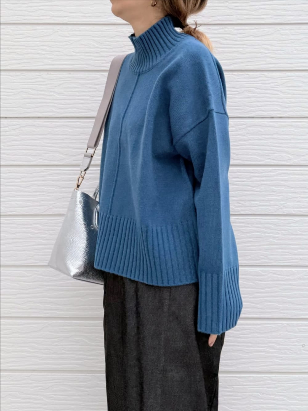 グレー系のスカート、ブラック系のブーツ、シルバー系のトートバッグを着用したレディースの冬コーディネートの5枚目の写真