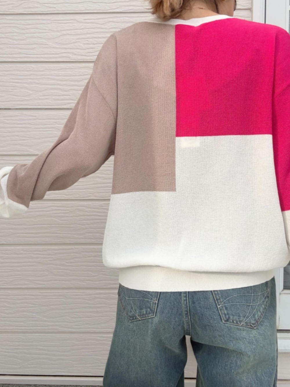 ブルー系のデニムパンツ、ホワイト系のニット/セーター、ブラック系のスニーカーを着用したレディースの冬コーディネートの5枚目の写真