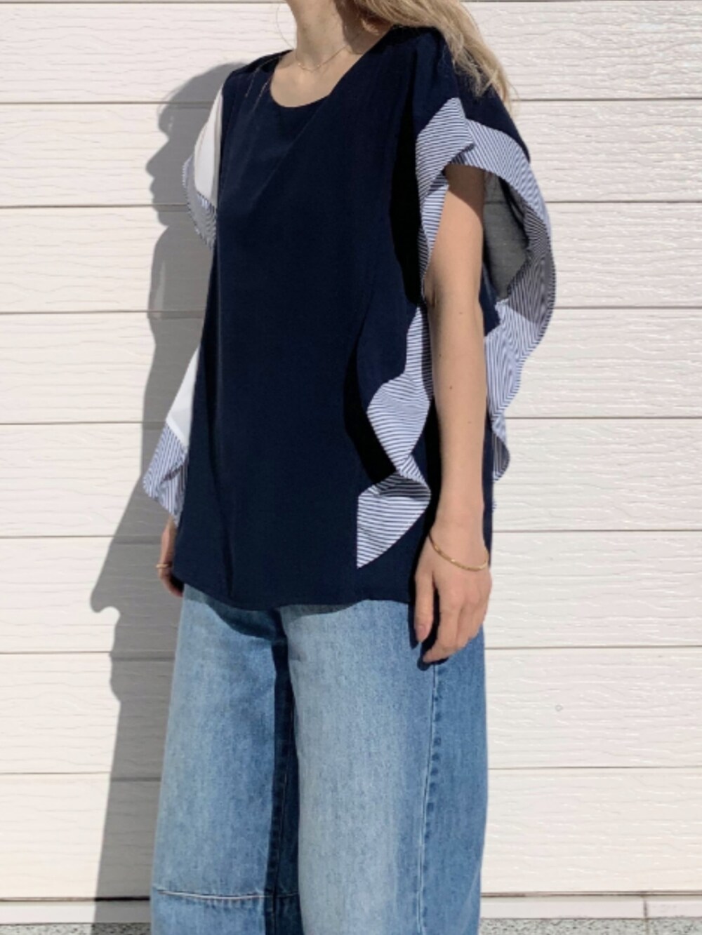 ブルー系のデニムパンツ、ベージュ系のボディバッグ/ウエストポーチ、ブルー系のシャツ/ブラウスを着用したレディースの春コーディネートの5枚目の写真