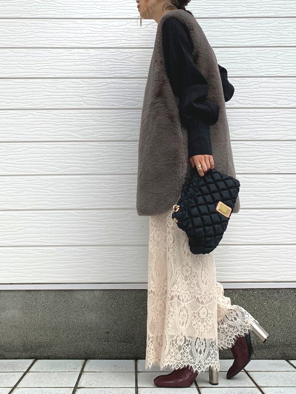 ブラック系のショルダーバッグ、ベージュ系のその他パンツ、ブラウン系のベストを着用したレディースの秋コーディネートの2枚目の写真