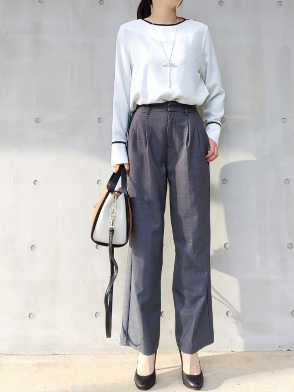 グレー系のスラックス、グレー系のノーカラージャケット、ホワイト系のシャツ/ブラウスを着用したレディースの冬コーディネートの2枚目の写真