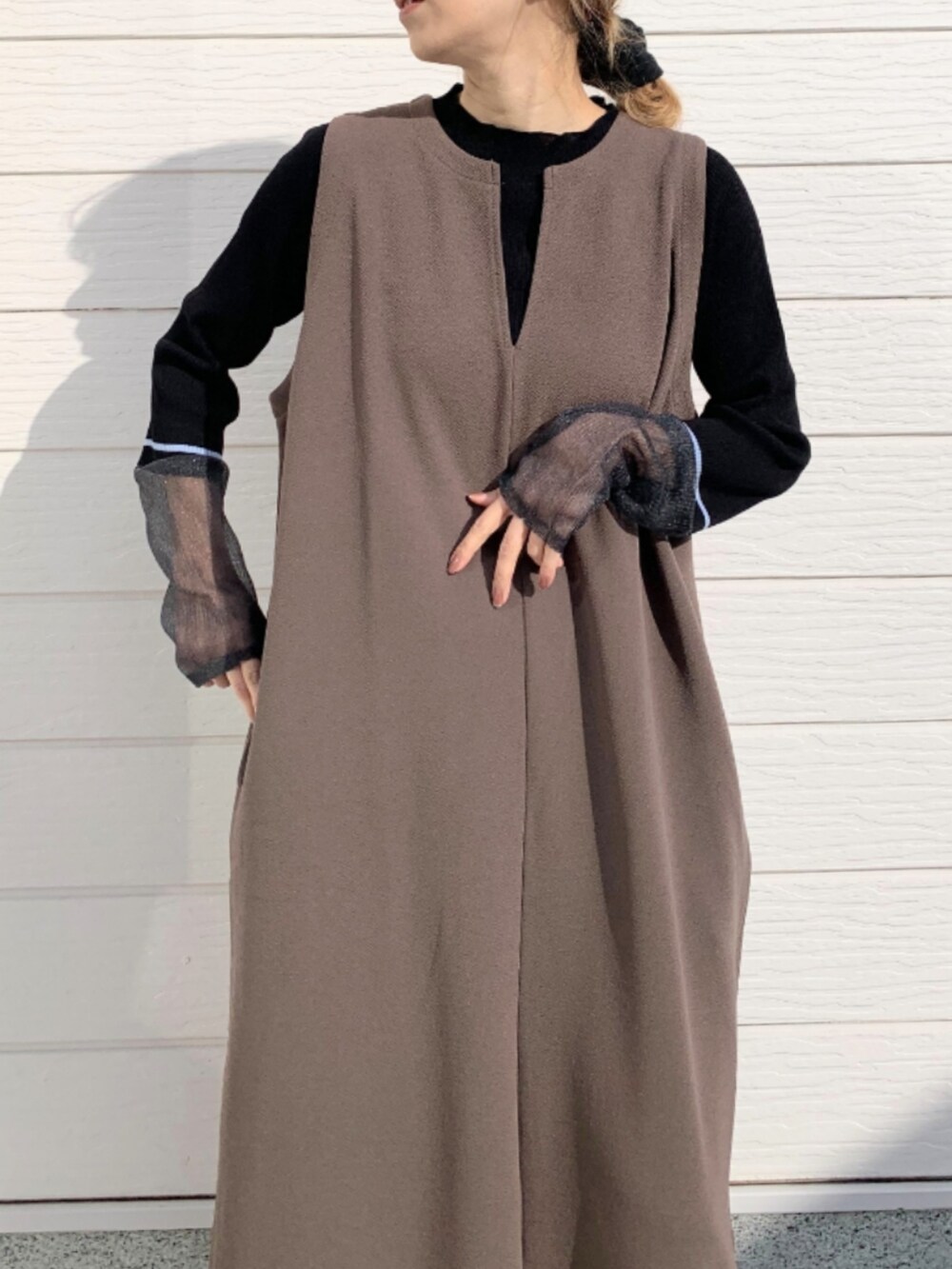 ブラック系のサンダル、ブラウン系のワンピース、ブラック系のニット/セーターを着用したレディースの冬コーディネートの3枚目の写真