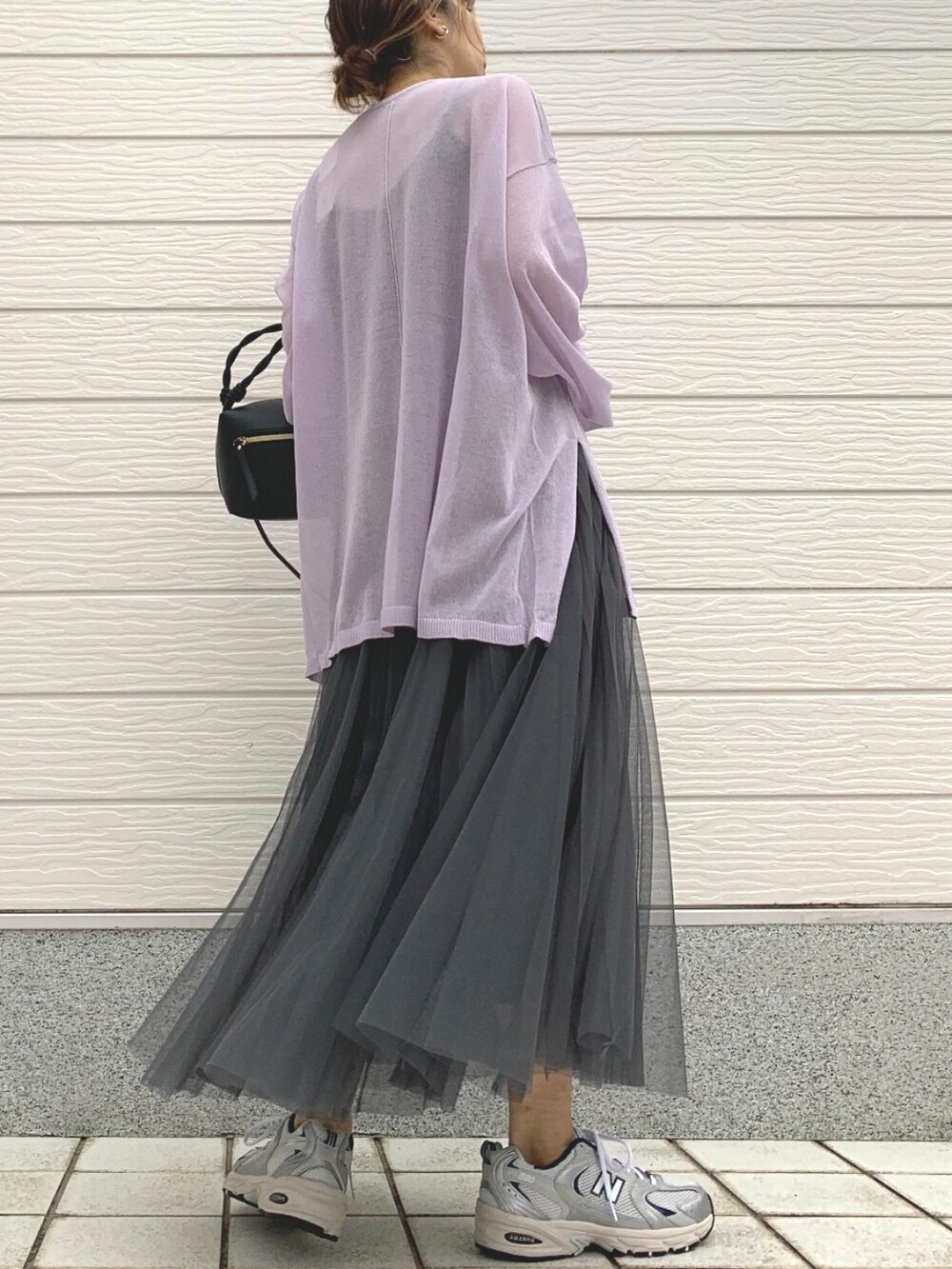 シルバー系のスニーカー、パープル系のニット/セーター、ブラック系のハンドバッグを着用したレディースの春コーディネートの3枚目の写真