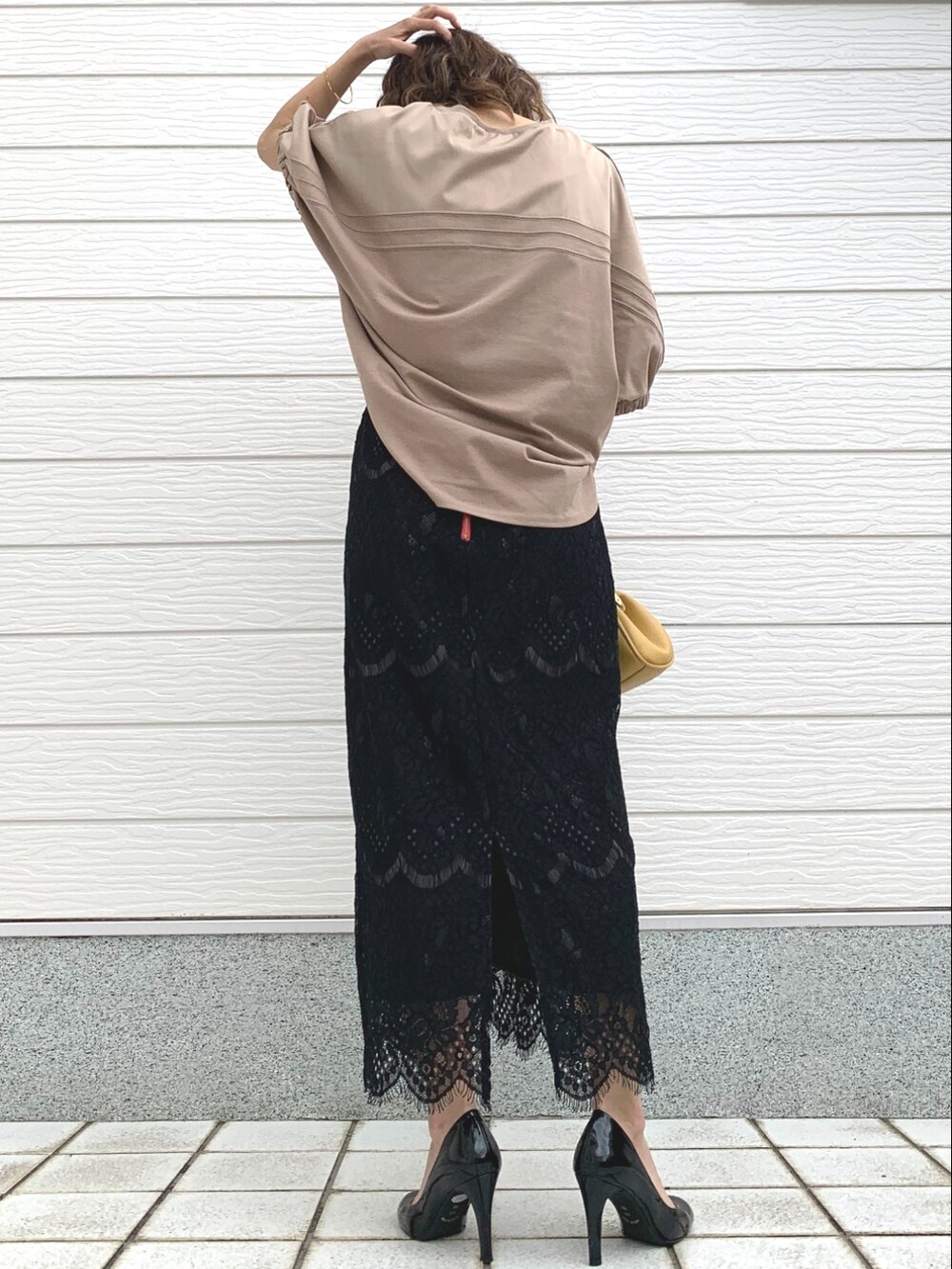 イエロー系のショルダーバッグ、ブラック系のスカート、イエロー系のTシャツ/カットソーを着用したレディースの春コーディネートの3枚目の写真