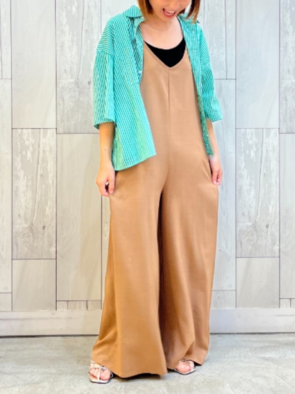 グリーン系のシャツ/ブラウス、ベージュ系のサロペット/オーバーオール、シルバー系のサンダルを着用したレディースの春コーディネートの2枚目の写真