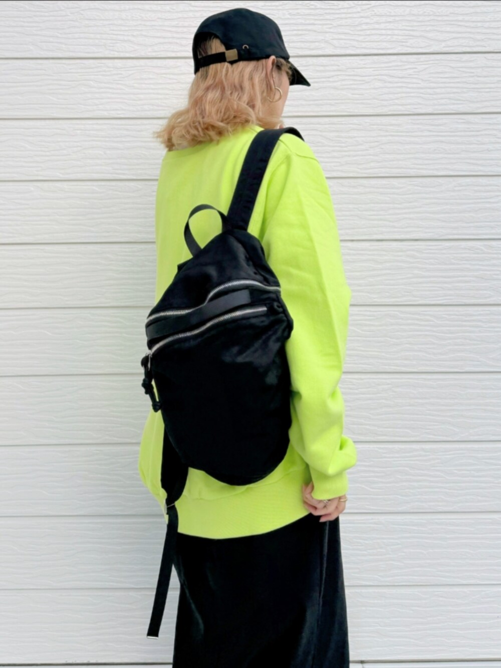 ブラック系のスカート、ホワイト系のTシャツ/カットソー、ブラック系のバックパック/リュックを着用したレディースの秋コーディネートの5枚目の写真