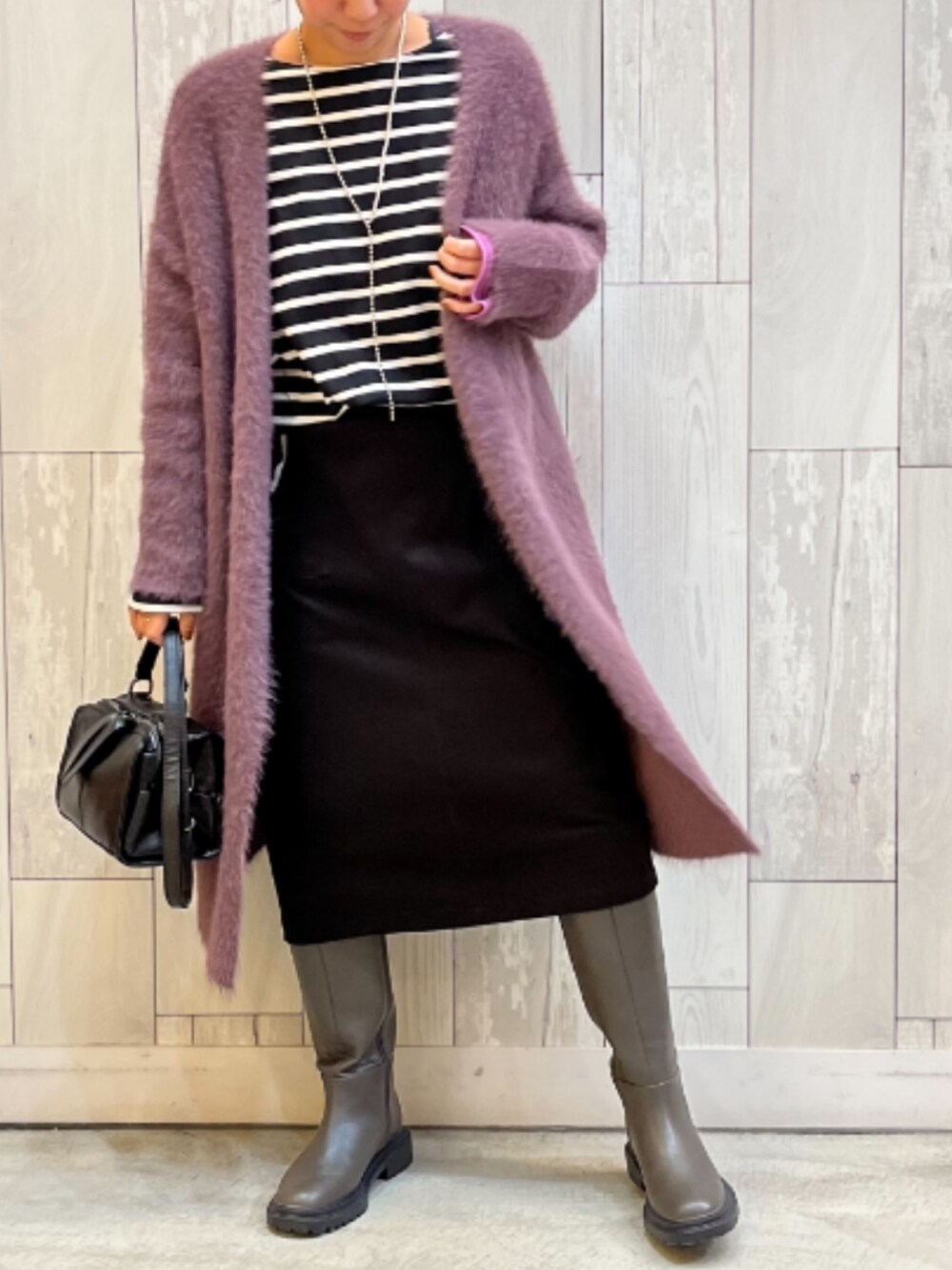 ブラック系のTシャツ/カットソー、ブラック系のスカート、グレー系のブーツを着用したレディースの秋コーディネートの2枚目の写真