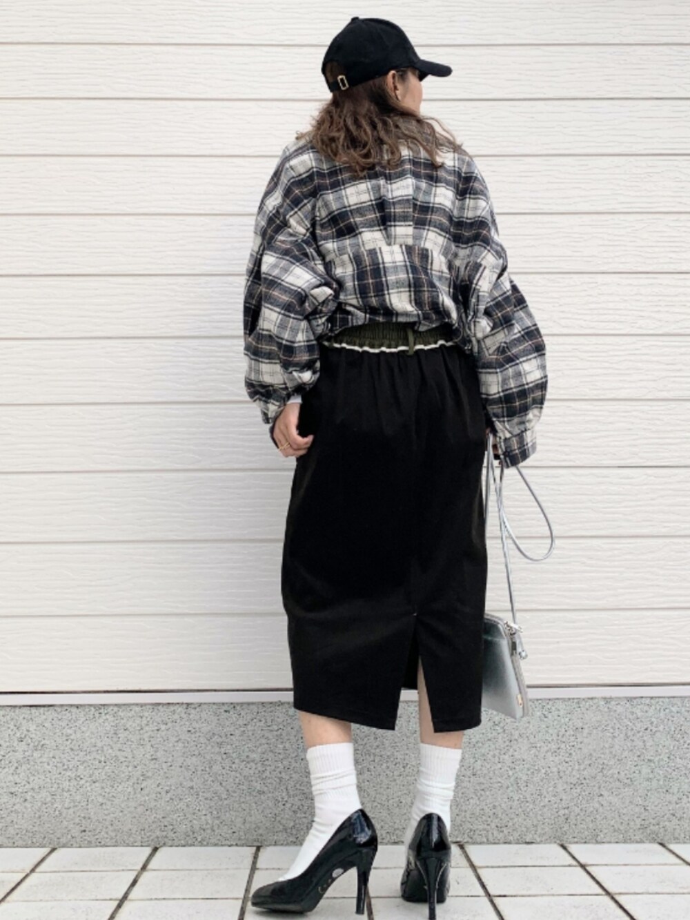 ホワイト系のTシャツ/カットソー、ブラック系のスカート、シルバー系のショルダーバッグを着用したレディースの秋コーディネートの3枚目の写真