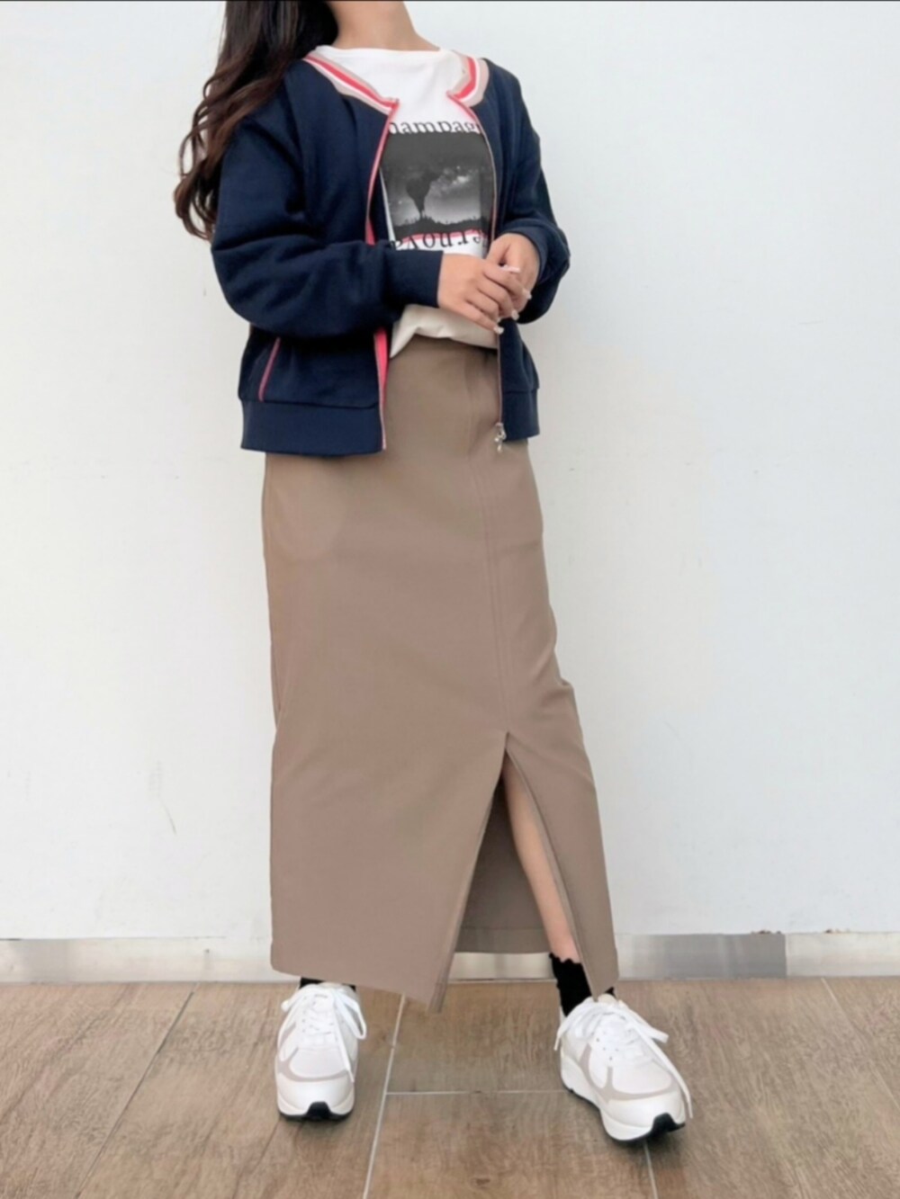 ベージュ系のスカート、ホワイト系のTシャツ/カットソー、ホワイト系のスニーカーを着用したレディースの冬コーディネートの3枚目の写真