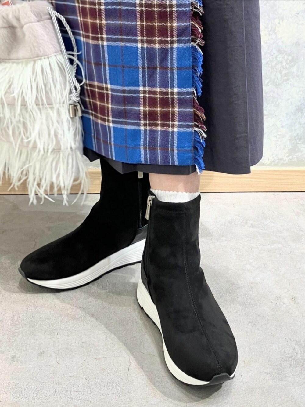 ブラック系のブーツ、グレー系のクラッチバッグ、ブラック系のニット/セーターを着用したレディースの秋コーディネートの5枚目の写真