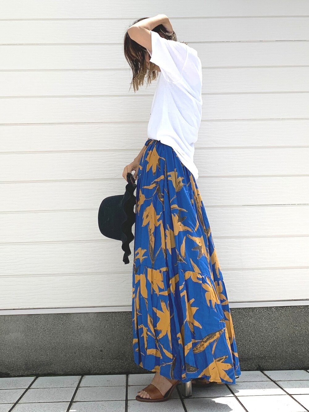 ブラウン系のサンダル、ブルー系のスカート、ホワイト系のTシャツ/カットソーを着用したレディースの夏コーディネートの2枚目の写真