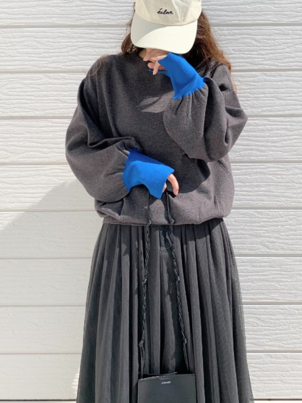 ブラック系のスカート、グレー系のニット/セーターを着用したレディースの秋コーディネートの5枚目の写真