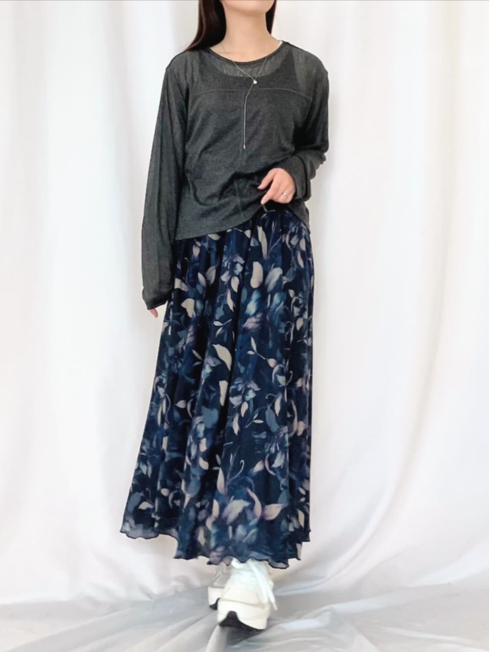 ホワイト系のスニーカー、ブルー系のスカート、グレー系のTシャツ/カットソーを着用したレディースの冬コーディネートの3枚目の写真