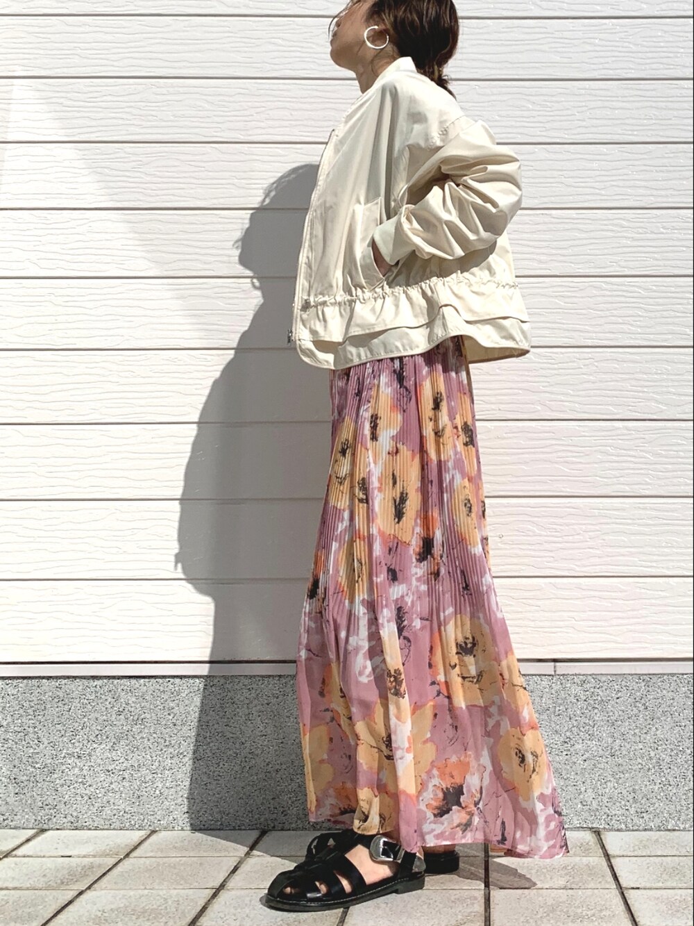 ベージュ系のブルゾン、ピンク系のスカート、ブラック系のサンダルを着用したレディースの春コーディネートの2枚目の写真