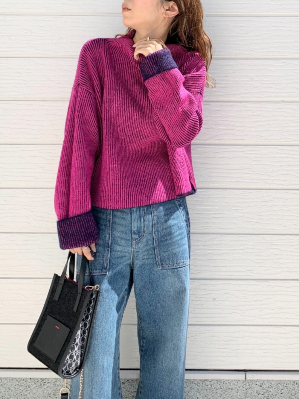 ブルー系のデニムパンツ、ブラック系のショルダーバッグ、ブルー系のニット/セーターを着用したレディースの秋コーディネートの3枚目の写真