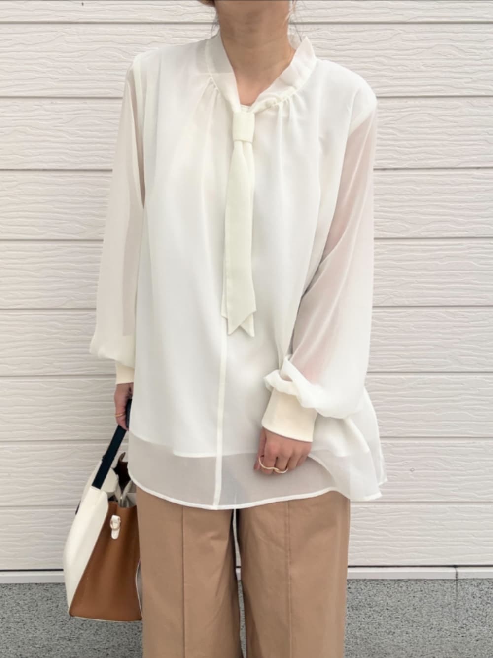 ベージュ系のその他パンツ、ホワイト系のシャツ/ブラウス、ホワイト系のトートバッグを着用したレディースの冬コーディネートの3枚目の写真