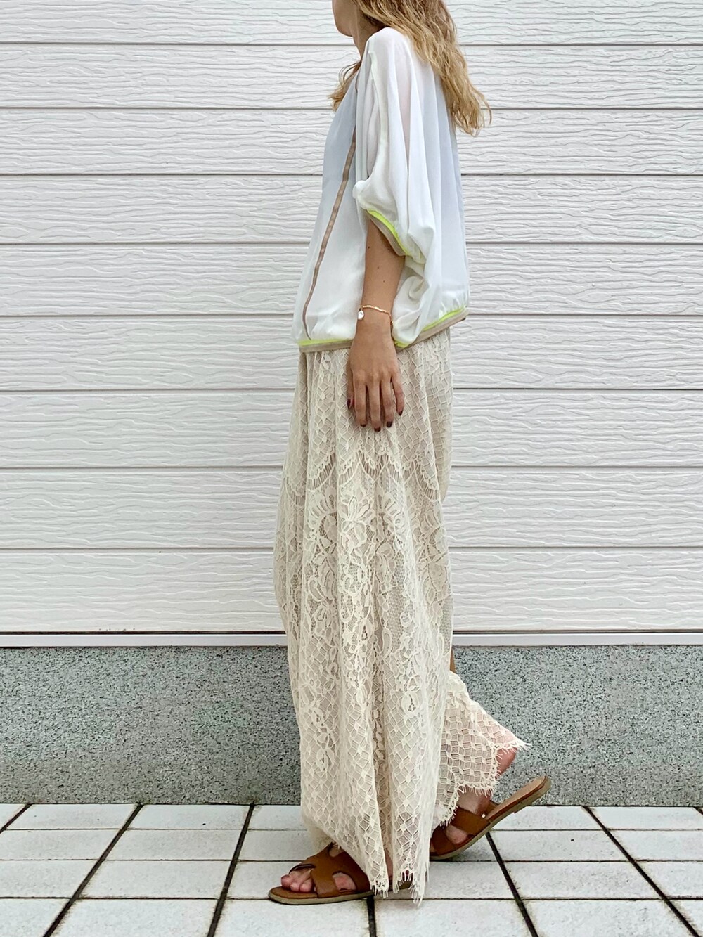 イエロー系のサンダル、ホワイト系のその他パンツ、ベージュ系のトートバッグを着用したレディースの夏コーディネートの2枚目の写真