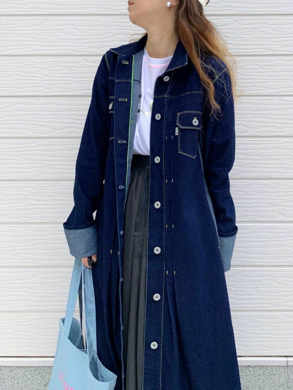 ブラック系のスカート、ホワイト系のスニーカー、ホワイト系のTシャツ/カットソーを着用したレディースの秋コーディネートの2枚目の写真