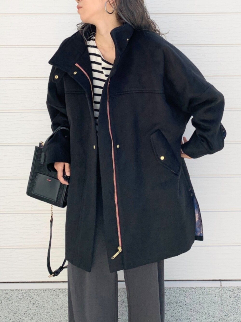 グレー系のその他パンツ、シルバー系のスニーカー、ブラック系のショルダーバッグを着用したレディースの秋コーディネートの3枚目の写真