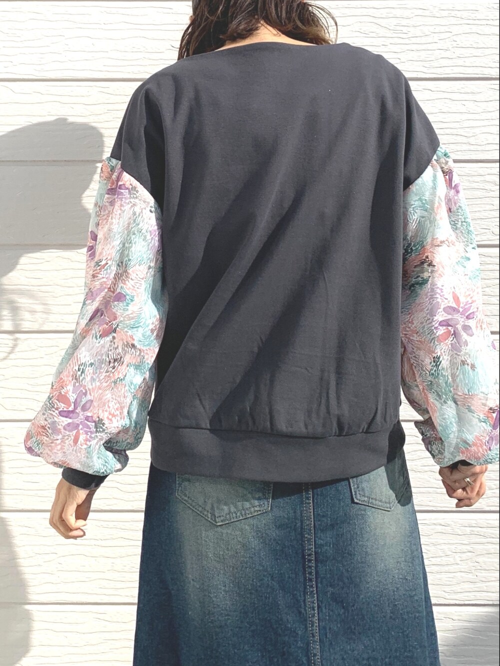 ブルー系のデニムスカート、グレー系のTシャツ/カットソー、ホワイト系のスニーカーを着用したレディースの冬コーディネートの4枚目の写真