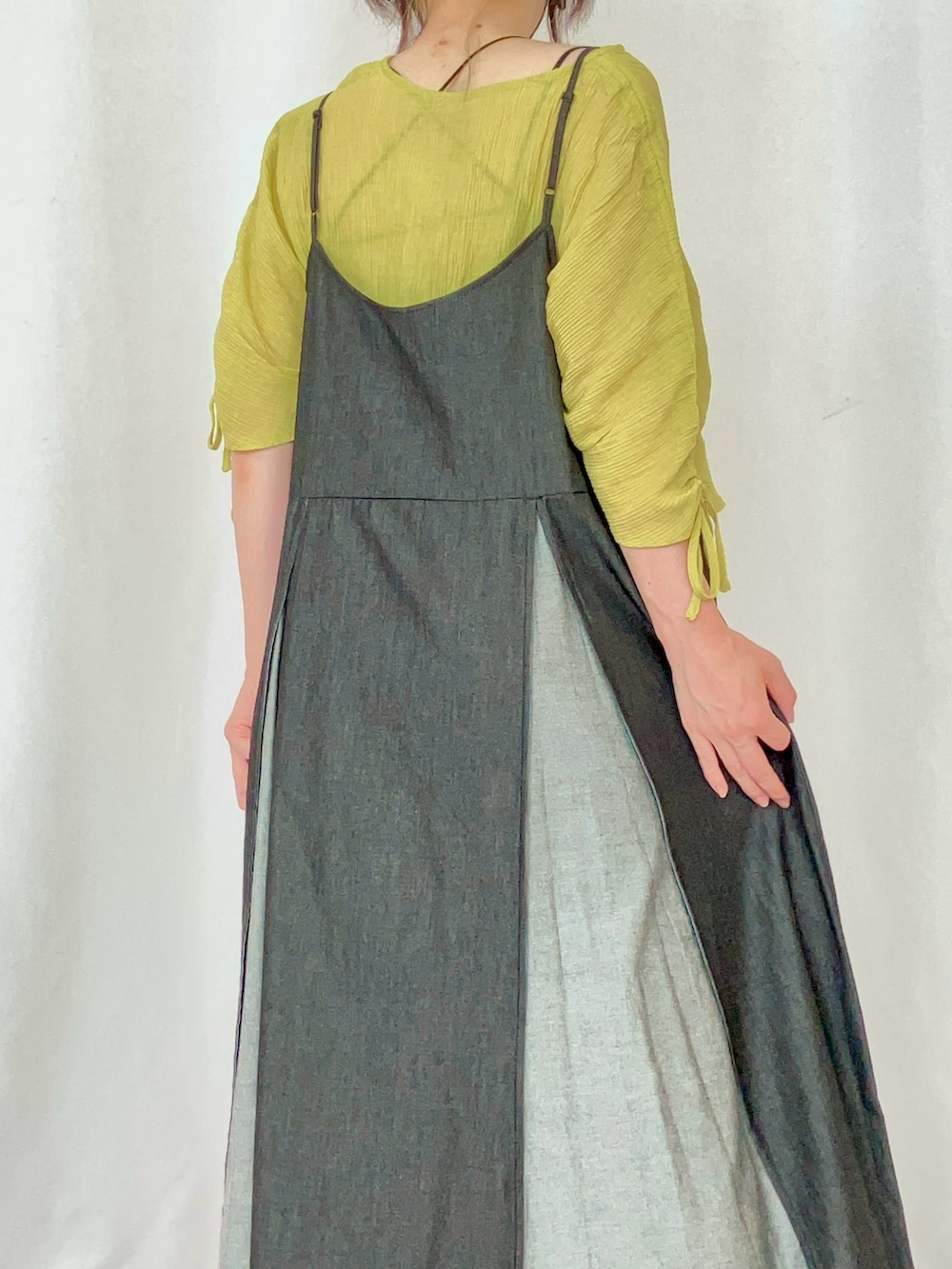 イエロー系のシャツ/ブラウス、ブラック系のワンピース、グレー系のサンダルを着用したレディースの夏コーディネートの5枚目の写真