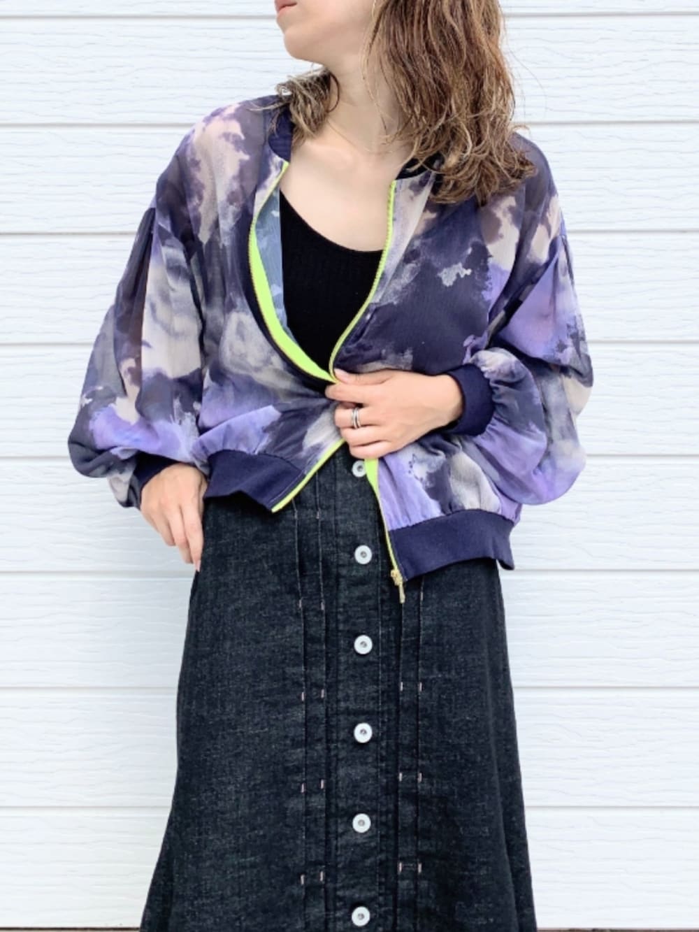 ブラック系のデニムスカート、ブルー系のブルゾン、ブラック系のキャミソールを着用したレディースの夏コーディネートの3枚目の写真