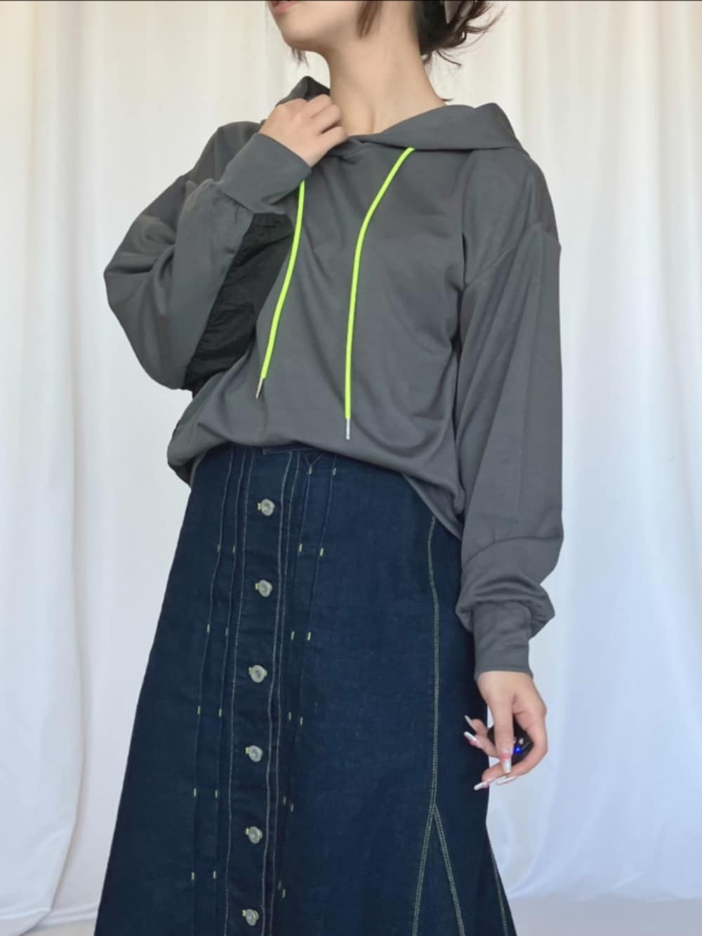 シルバー系のスニーカー、ブルー系のデニムスカート、グレー系のパーカーを着用したレディースの冬コーディネートの4枚目の写真