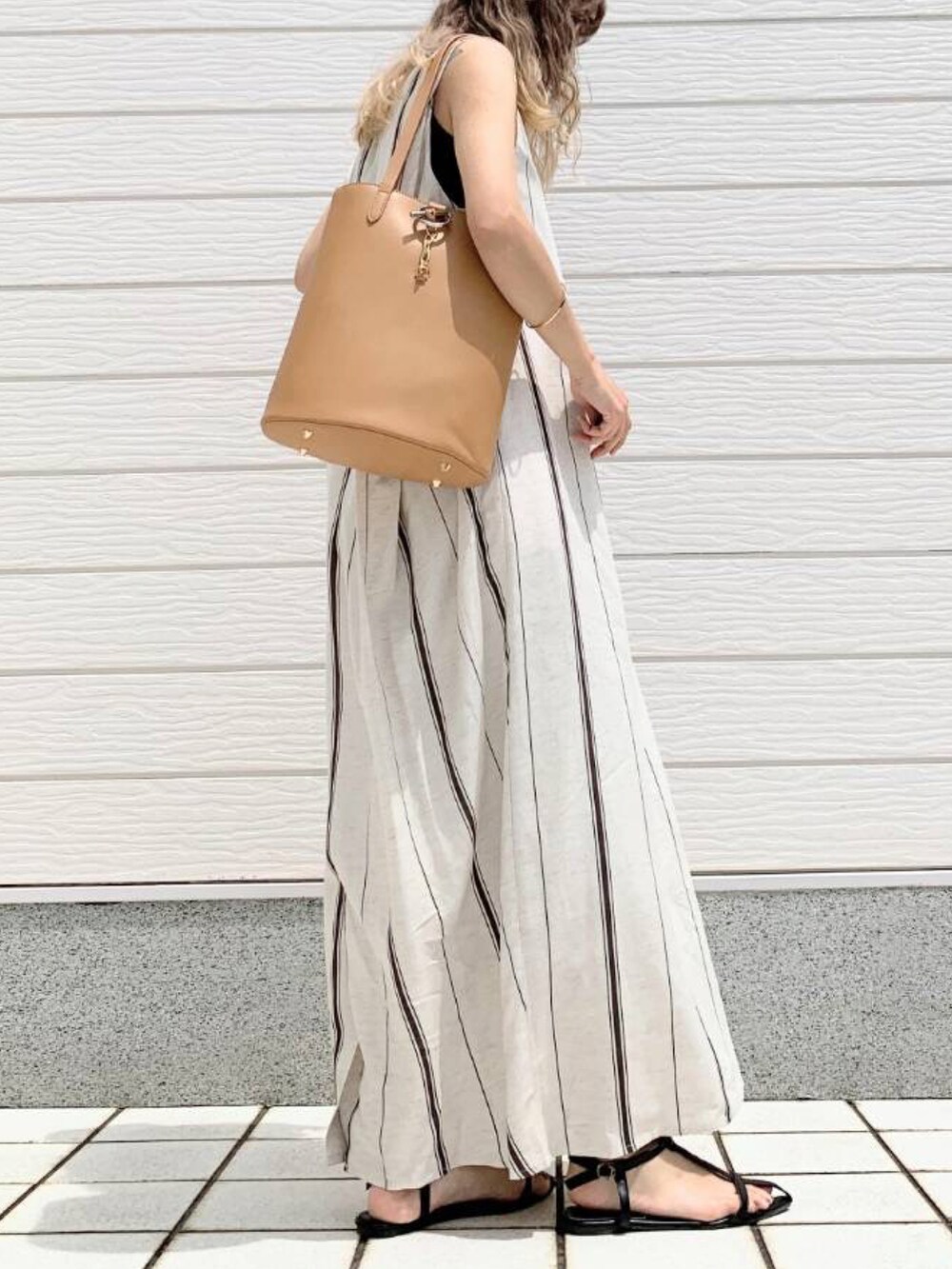 ベージュ系のトートバッグ、グリーン系のワンピースを着用したレディースの春コーディネートの3枚目の写真