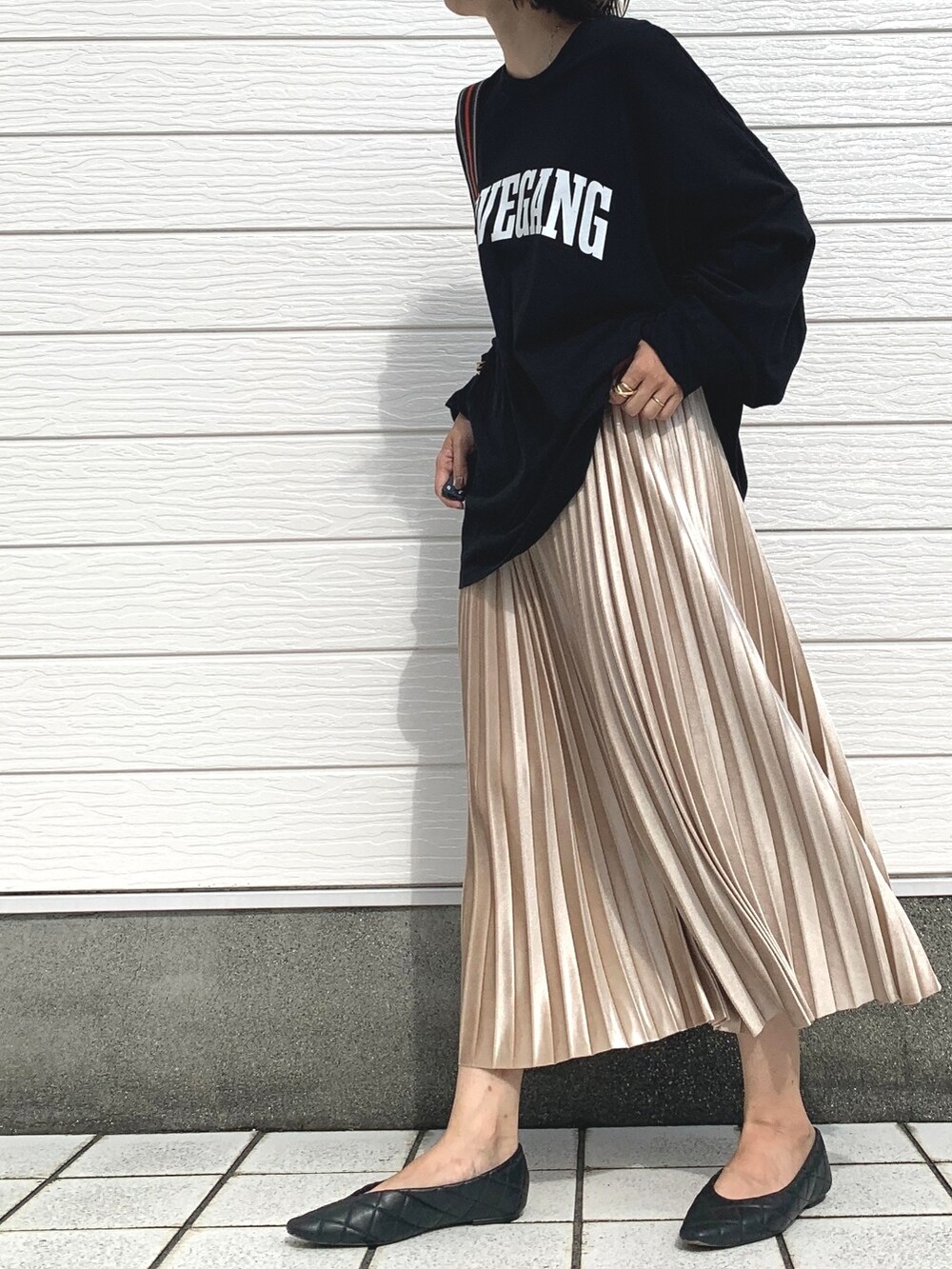 ベージュ系のスカート、ブラック系のTシャツ/カットソー、ブラック系のショルダーバッグを着用したレディースの秋コーディネートの2枚目の写真