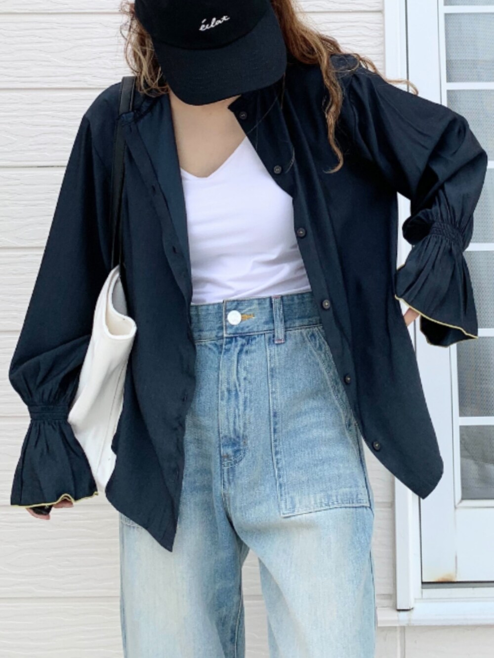 ブルー系のデニムパンツ、ホワイト系のトートバッグ、ブルー系のシャツ/ブラウスを着用したレディースの夏コーディネートの5枚目の写真