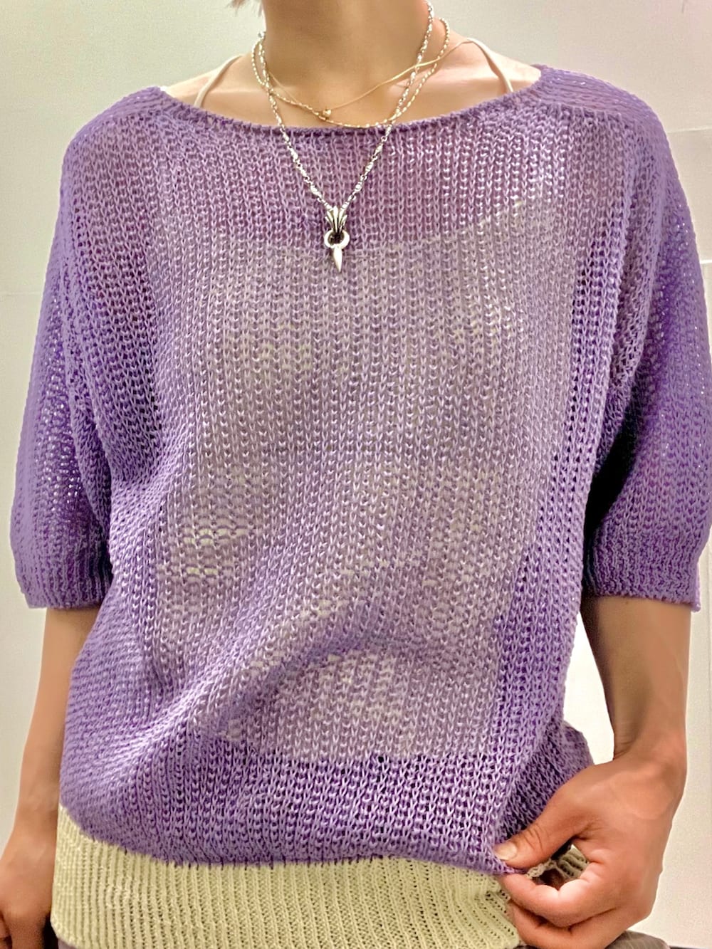 パープル系のニット/セーター、グレー系のスラックス、ブラック系のボストンバッグを着用したレディースの夏コーディネートの2枚目の写真