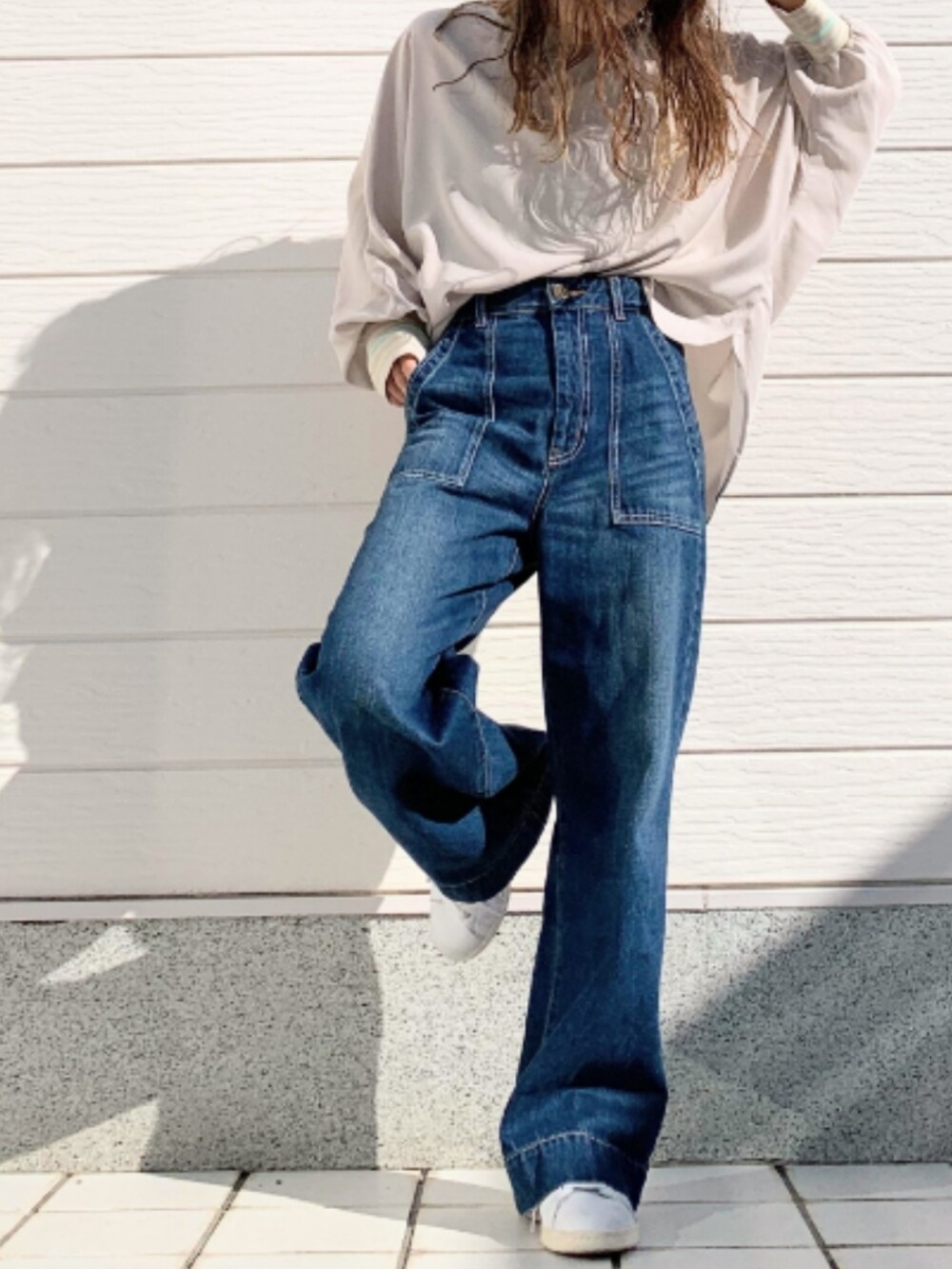 ブルー系のデニムパンツ、ホワイト系のスニーカー、ベージュ系のシャツ/ブラウスを着用したレディースの冬コーディネートの2枚目の写真