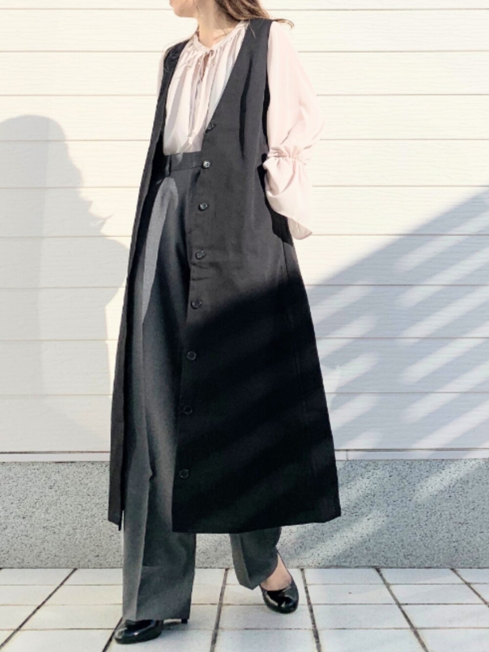ブラウン系のブーツ、ベージュ系のシャツ/ブラウス、ブラック系のジャンパースカートを着用したレディースの冬コーディネートの5枚目の写真