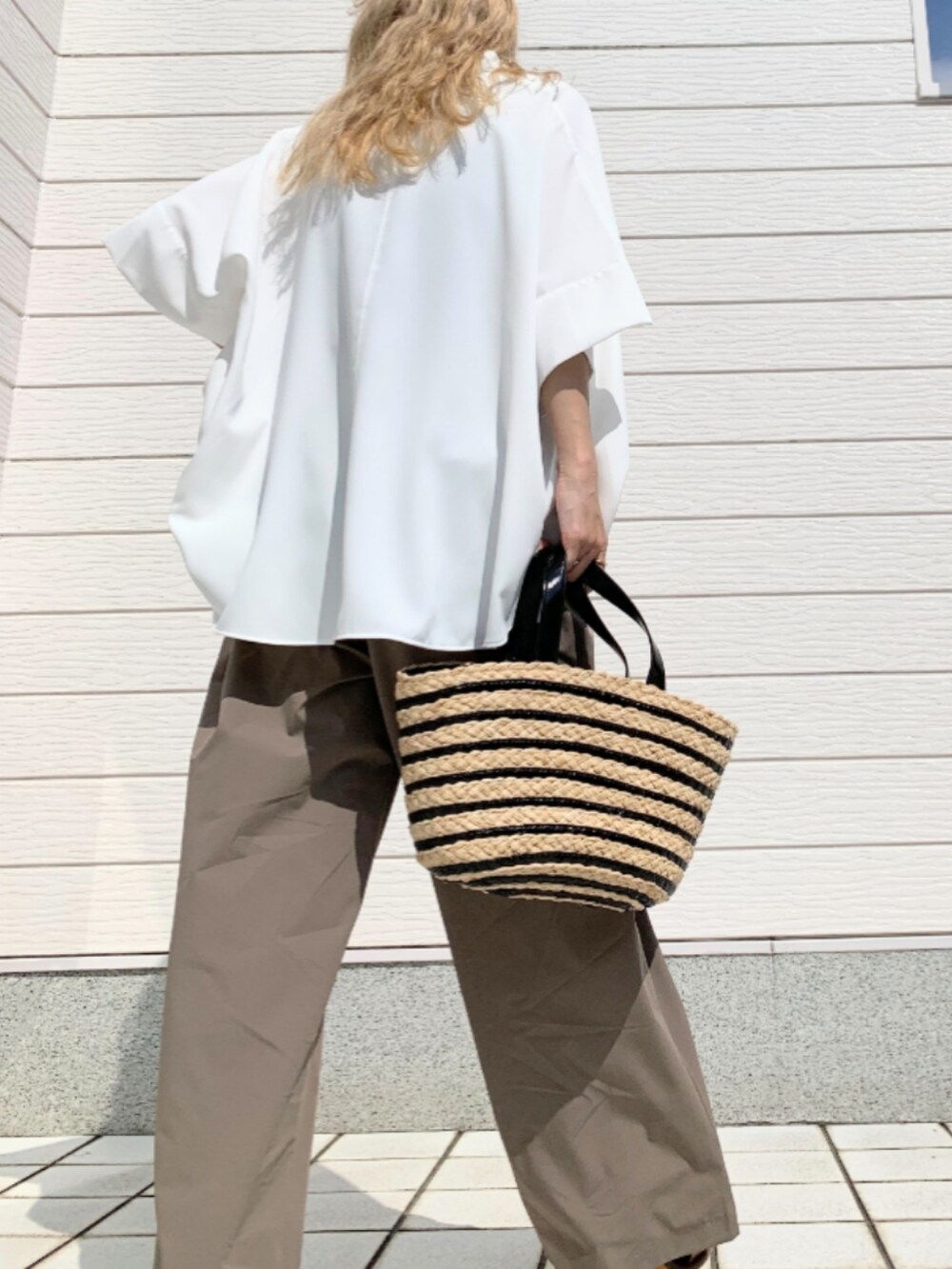 ブラック系のかごバッグ、グレー系のその他パンツ、ホワイト系のシャツ/ブラウスを着用したレディースの春コーディネートの2枚目の写真