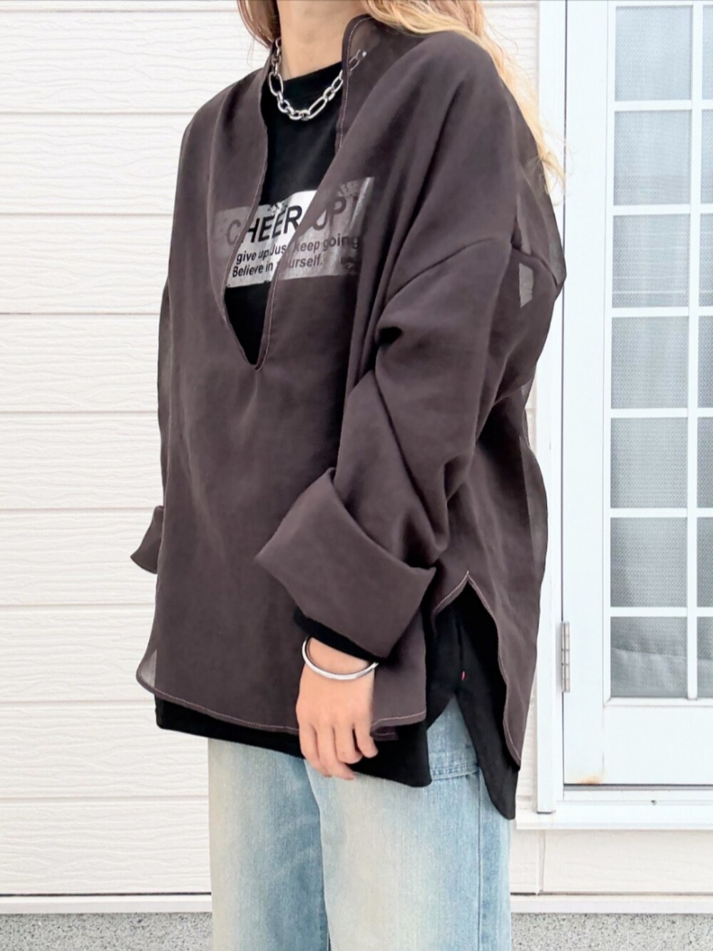 ブルー系のデニムパンツ、ブラック系のTシャツ/カットソー、ブラウン系のシャツ/ブラウスを着用したレディースの秋コーディネートの4枚目の写真