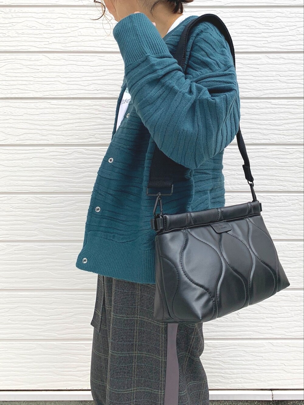 グリーン系のカーディガン/ボレロ、ホワイト系のTシャツ/カットソー、ブラック系のクラッチバッグを着用したレディースの秋コーディネートの4枚目の写真