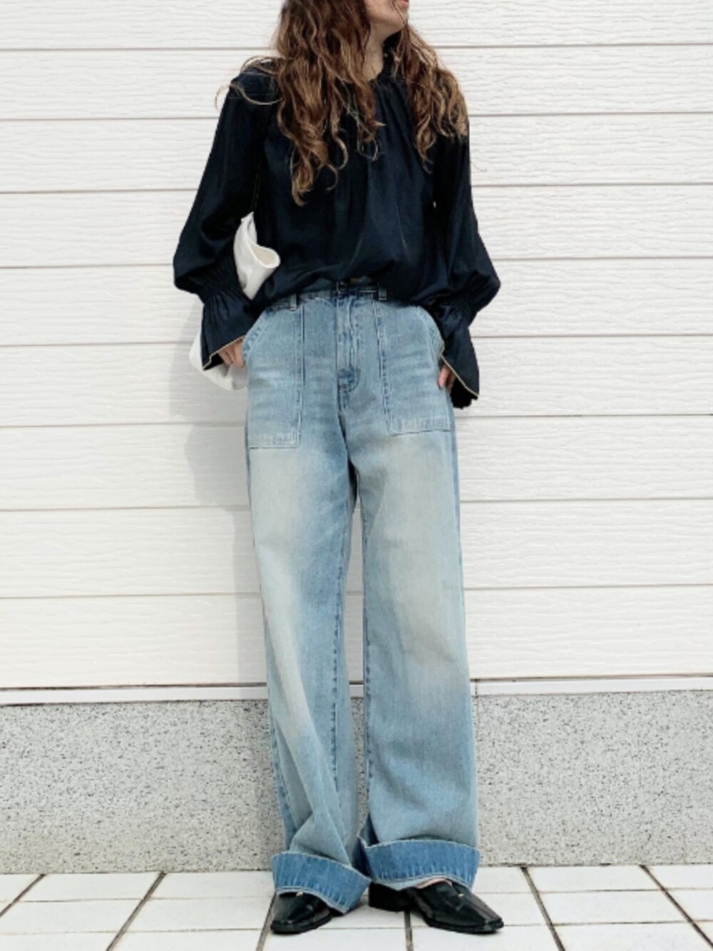 ブルー系のデニムパンツ、ホワイト系のトートバッグ、ブルー系のシャツ/ブラウスを着用したレディースの夏コーディネートの2枚目の写真