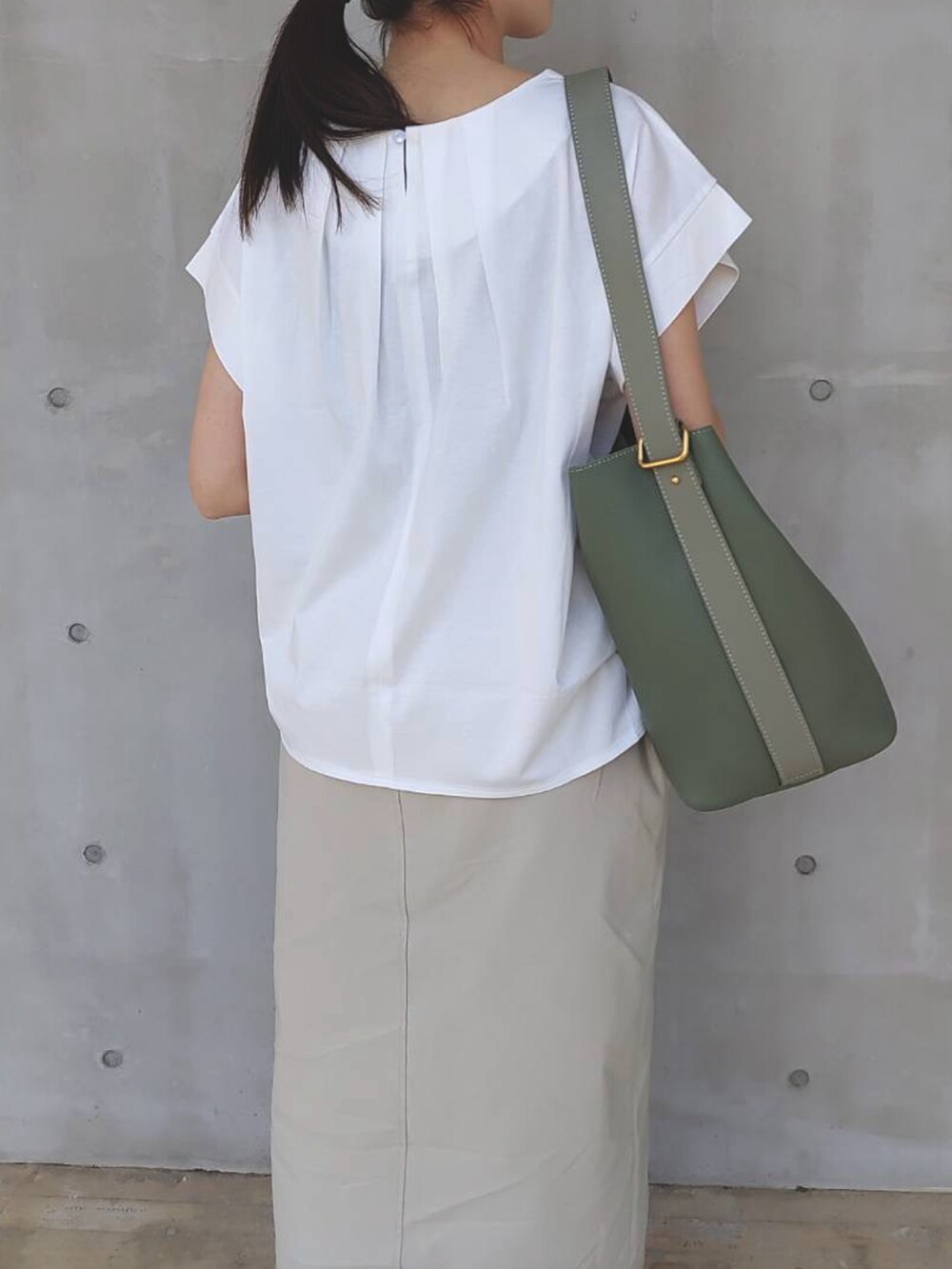 ホワイト系のTシャツ/カットソー、イエロー系のカーディガン/ボレロ、ベージュ系のスカートを着用したレディースの春コーディネートの5枚目の写真