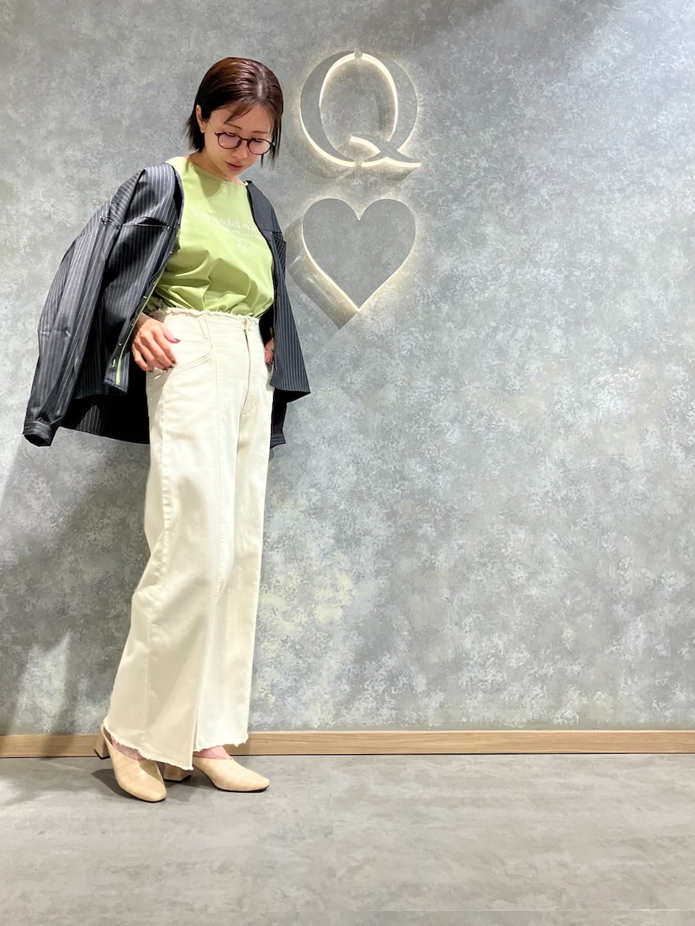 ホワイト系のデニムパンツ、グレー系のノーカラージャケット、グリーン系のTシャツ/カットソーを着用したレディースの春コーディネートの3枚目の写真