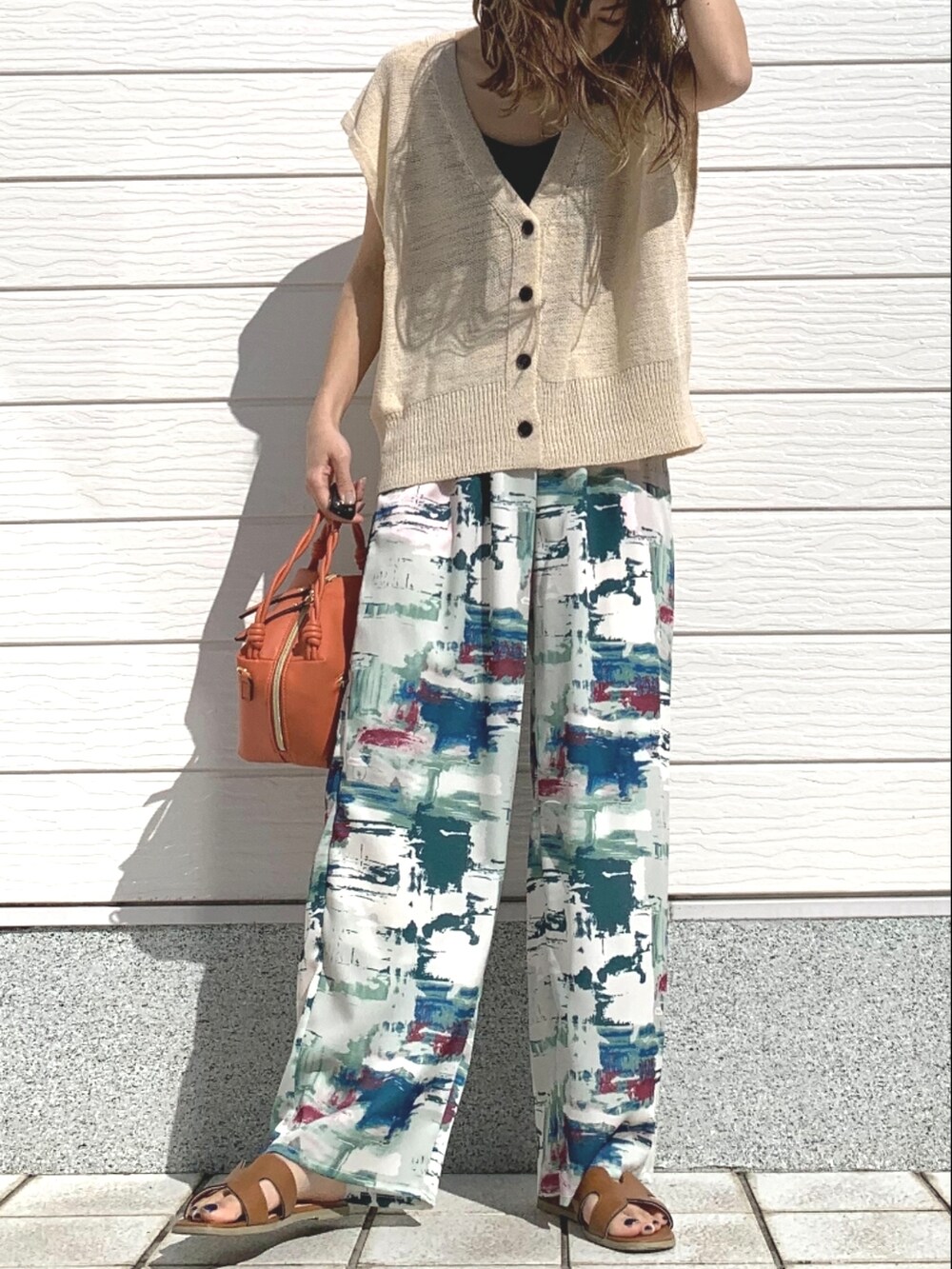 グリーン系のその他パンツ、イエロー系のサンダル、ホワイト系のベストを着用したレディースの春コーディネートの2枚目の写真