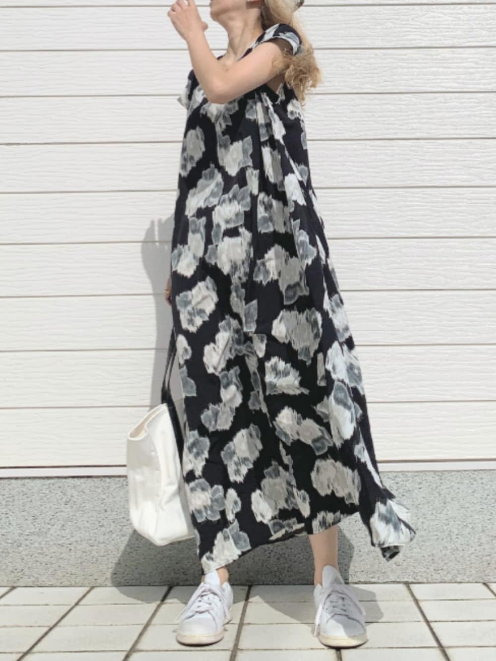 ブラック系のワンピース、ホワイト系のスニーカー、ホワイト系のトートバッグを着用したレディースの春コーディネートの3枚目の写真